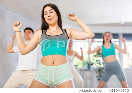 Emotional teen girl dancing krump with group in modern studio Emotional teen girl dancing krump with group in modern studio 141041450