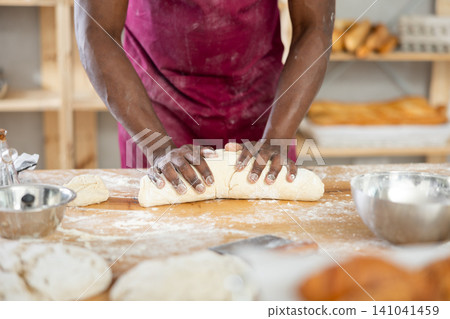 Close-up of professional African baker kneading dough Close-up of professional African baker kneading dough 141041459