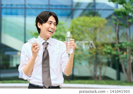 一位商人頂著烈日在戶外喝水。 141041503