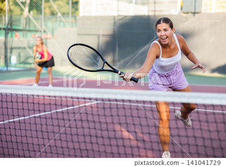 Stunning fit girl with trained body wearing in sport clothes hitting ball on court. Female fitness concept 141041729