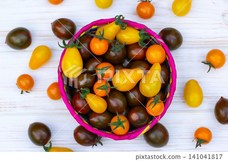Colorful organic cherry tomatoes on the white wooden table. Colorful organic cherry tomatoes on the white wooden table. 141041817