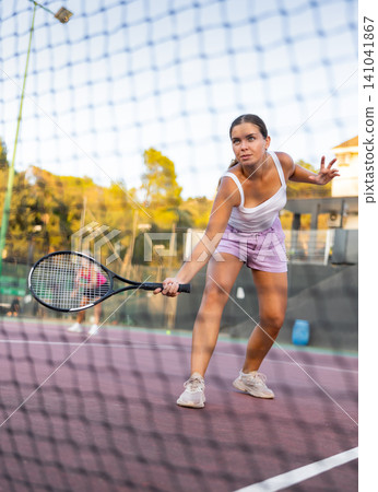 Woman tennis player training on court Woman tennis player training on court 141041867