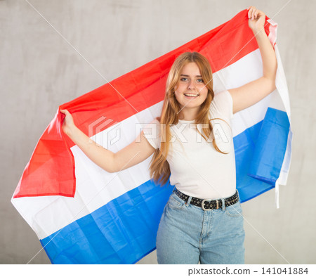 Attractive female student holding Netherlands flag Attractive female student holding Netherlands flag 141041884