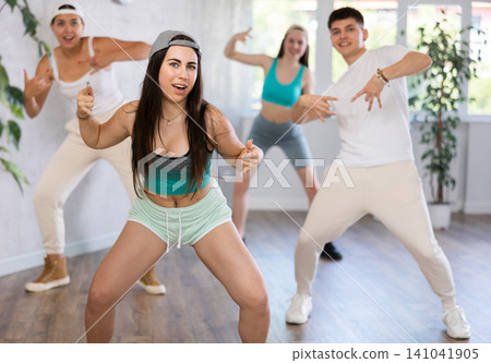 Active teenagers dancing modern dances in modern studio 141041905