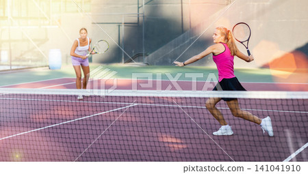 Young woman in skirt playing tennis on court Young woman in skirt playing tennis on court 141041910