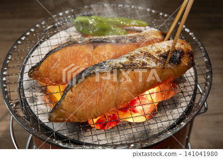 用木炭烤鮭魚。 用木炭烤鮭魚。 141041980