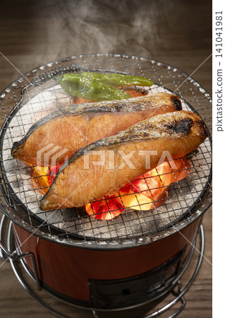 用木炭烤鮭魚。 用木炭烤鮭魚。 141041981
