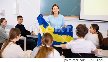 Female professor shows students flag of Sweden Female professor shows students flag of Sweden 141042218