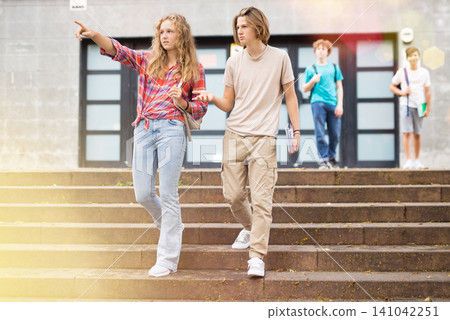 Teenager girl and boy going home after school 141042251