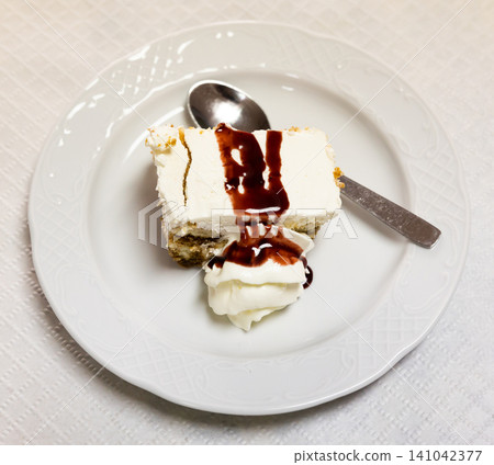 Tiramisu slice with white mascarpone cream and chocolate sauce 141042377