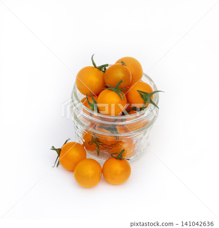 Jar of bright orange cherry tomatoes on the white background. Jar of bright orange cherry tomatoes on the white background. 141042636