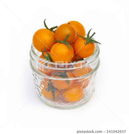 Jar of bright orange cherry tomatoes on the white background. Jar of bright orange cherry tomatoes on the white background. 141042637