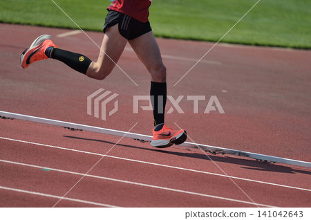 Track and field running on a track Track and field running on a track 141042643