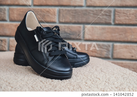 Elegant black leather womens shoes blank product for branding displayed. New casual female sneakers no-brand footwear e-commerce. No logo product Elegant black leather womens shoes blank product for branding displayed. New casual female sneakers no-brand footwear e-commerce. No logo product 141042852