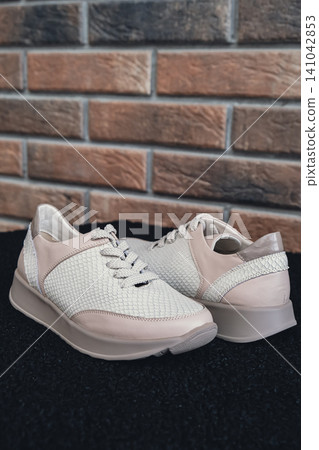 Fresh beige leather sneakers without brand marks displayed. For design templates online shops and sustainability-themed marketing. Clean blank sneakers Fresh beige leather sneakers without brand marks displayed. For design templates online shops and sustainability-themed marketing. Clean blank sneakers 141042853