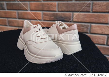 Fresh beige leather sneakers without brand marks displayed. For design templates online shops and sustainability-themed marketing. Clean blank sneakers Fresh beige leather sneakers without brand marks displayed. For design templates online shops and sustainability-themed marketing. Clean blank sneakers 141042857