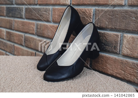 Elegant black leather womens shoes displayed. New black leather female shoes with glossy finish, perfect for style magazines footwear ads and modern elegant fashion e-commerce layouts. No logo Elegant black leather womens shoes displayed. New black leather female shoes with glossy finish, perfect for style magazines footwear ads and modern elegant fashion e-commerce layouts. No logo 141042865