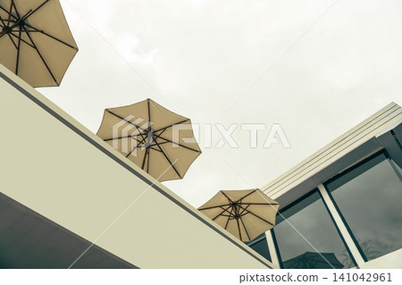 Parasols sit atop a modern structure in Bali under a grey sky Parasols sit atop a modern structure in Bali under a grey sky 141042961