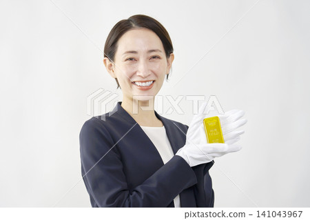 女性鑑定師手持金條，白色背景 141043967