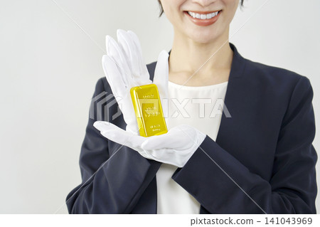 女性鑑定師手持金條，白色背景 141043969