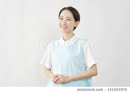 Smiling female caregiver against a white background Smiling female caregiver against a white background 141043978