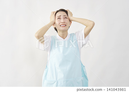 一位女護理員托著頭，背景是白色。 141043981