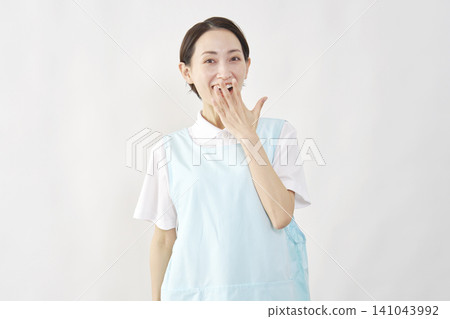 一位女護理員在白色背景前露出驚訝的笑容。 141043992