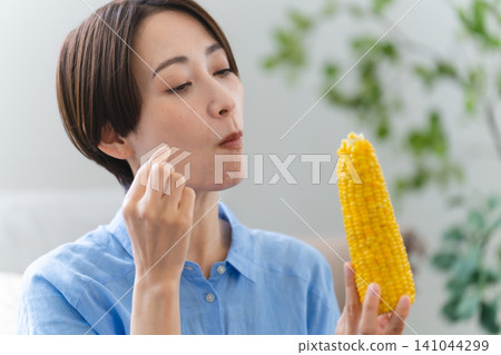 Young woman eating corn lifestyle image Young woman eating corn lifestyle image 141044299