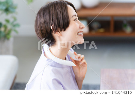 Young woman wearing a cooling neckband Lifestyle image Young woman wearing a cooling neckband Lifestyle image 141044310
