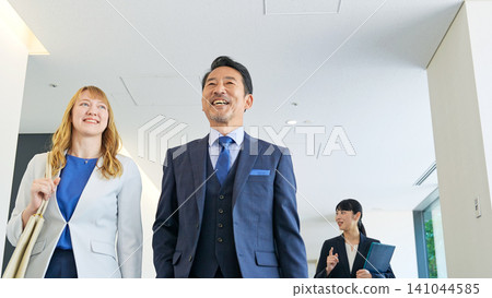 Group of multinational business people walking through a building and talking Group of multinational business people walking through a building and talking 141044585
