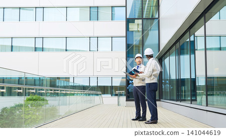 A group of multinational engineers having a conversation in front of a building A group of multinational engineers having a conversation in front of a building 141044619