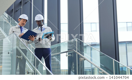 Group of multinational engineers having a conversation in a building Group of multinational engineers having a conversation in a building 141044704
