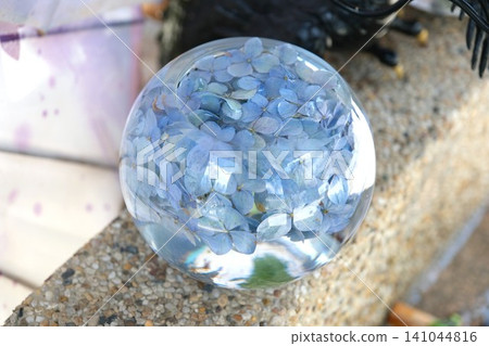 A blue hydrangea decoration in a round glass container. A blue hydrangea decoration in a round glass container. 141044816