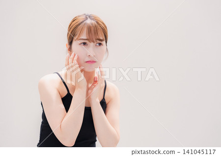 A young woman with light-colored hair who is troubled by skin problems. 141045117