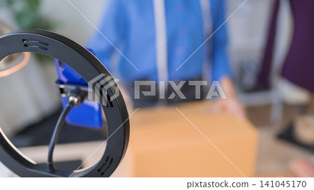 Modern ring light and microphone setup for online merchant recording product video in home studio with blurred workspace Modern ring light and microphone setup for online merchant recording product video in home studio with blurred workspace 141045170
