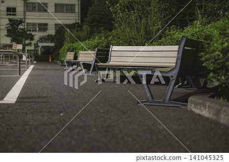 A deserted bench on a sidewalk at night A deserted bench on a sidewalk at night 141045325