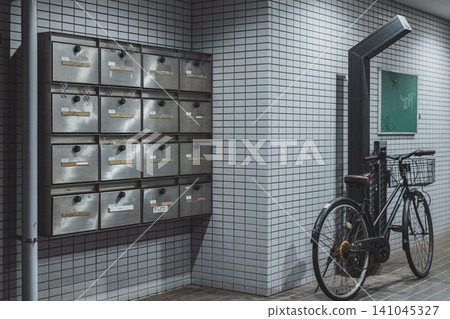 A communal mailbox in an apartment building; a common corridor where bicycles are parked. A communal mailbox in an apartment building; a common corridor where bicycles are parked. 141045327