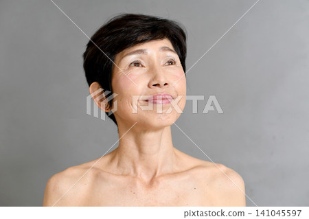 一位年長的亞洲女性面帶微笑,眺望著未來。 一位年長的亞洲女性面帶微笑,眺望著未來。 141045597