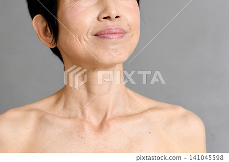 A senior Asian woman smiles as she looks towards the future. A senior Asian woman smiles as she looks towards the future. 141045598