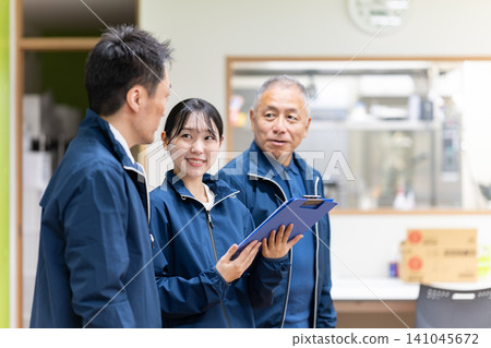 Staff members having a meeting in front of the kitchen Staff members having a meeting in front of the kitchen 141045672