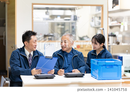 Staff members having a meeting in front of the kitchen Staff members having a meeting in front of the kitchen 141045758