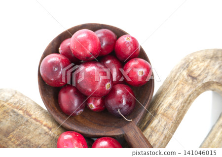 Fresh cranberries in a wooden spoon, ready for cooking or snacking Fresh cranberries in a wooden spoon, ready for cooking or snacking 141046015