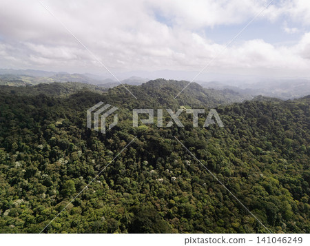 Lush green mountains stretch across the horizon under a cloudy sky Lush green mountains stretch across the horizon under a cloudy sky 141046249