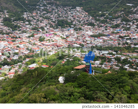 City view from hilltop showing buildings and a large sculpture 141046285