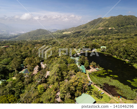 Cloudy sky above forest and pond in mountain area during daytime 141046296