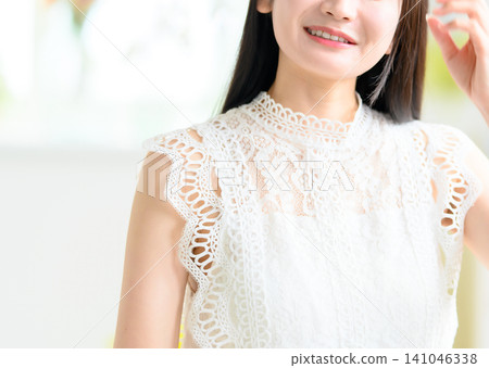 一位身穿白色蕾絲連身裙的女士的臉部特寫。 一位身穿白色蕾絲連身裙的女士的臉部特寫。 141046338