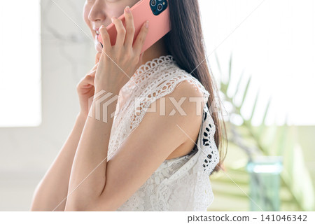 一位身穿蕾絲服裝的女子正在打電話。 141046342
