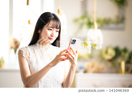 A woman looking at her smartphone with a happy expression. A woman looking at her smartphone with a happy expression. 141046369