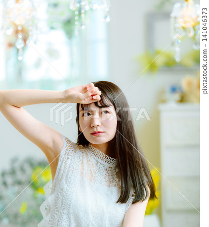 一個女人手扶額頭，凝視前方。 141046373