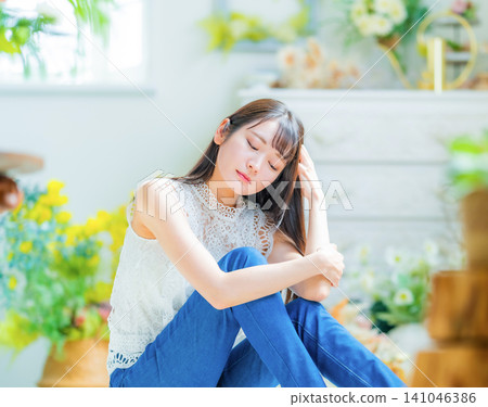 A woman sits down and closes her eyes. A woman sits down and closes her eyes. 141046386